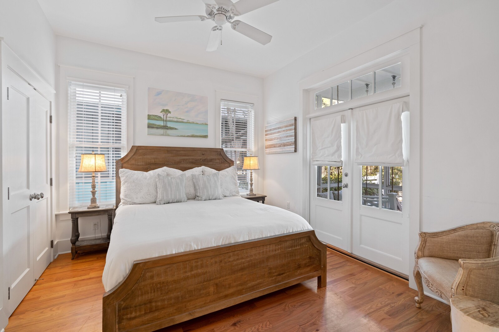 Bright king bedroom with wood bed and white linens