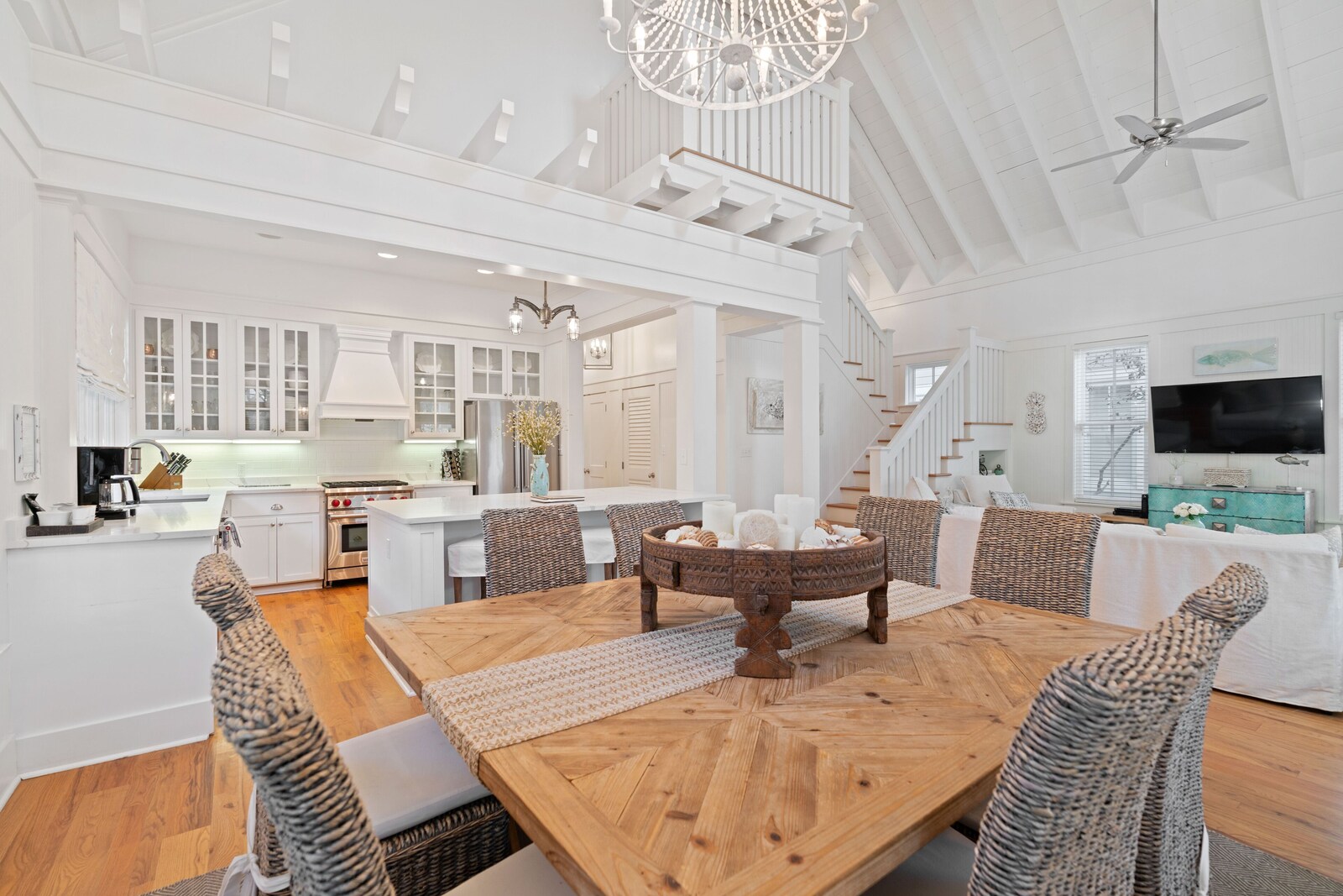 Dining area with wood table, wicker chairs, and open kitchen