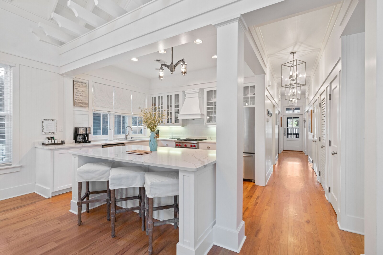 White gourmet kitchen with marble island and bar seating