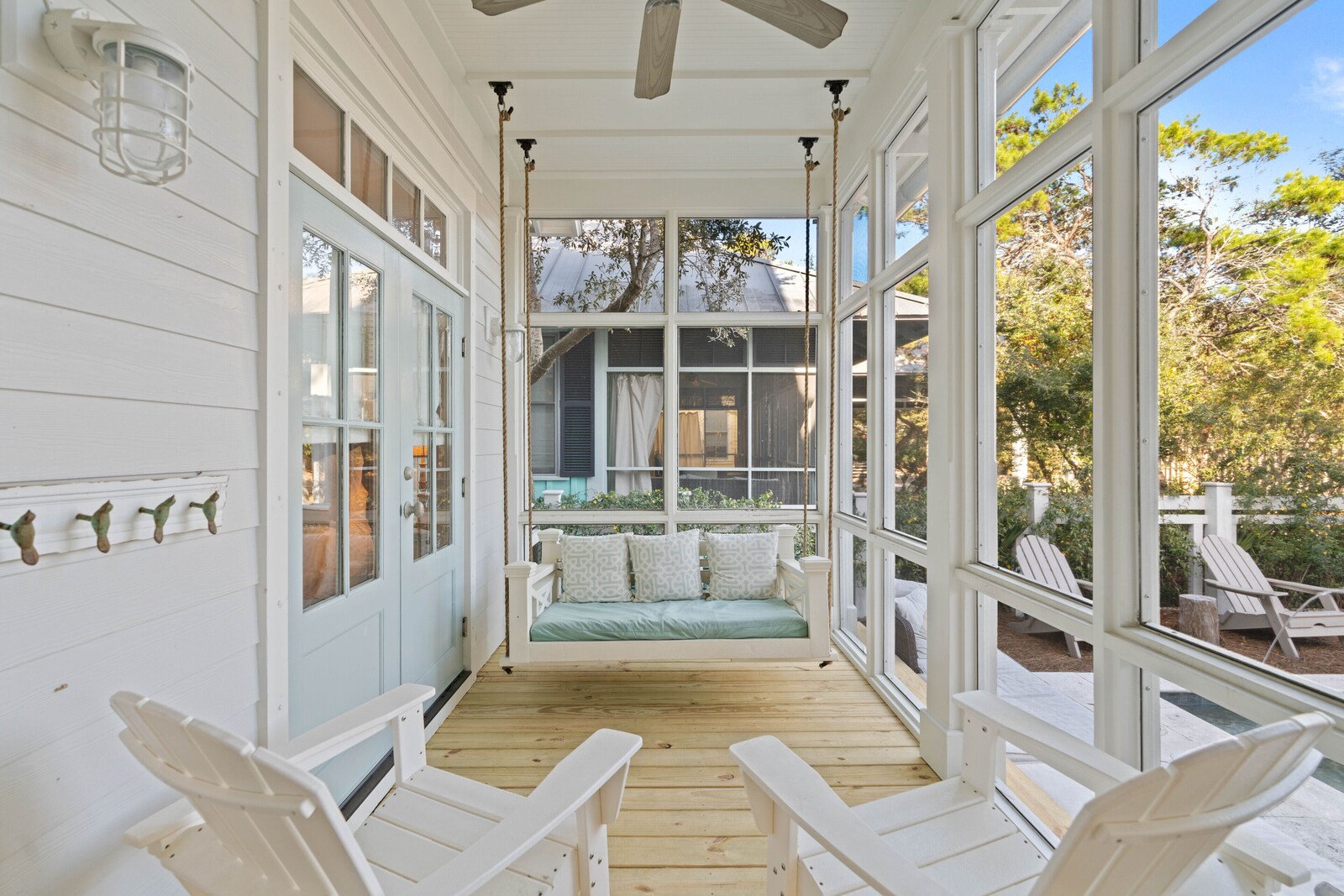 Screened porch with bed swing and Adirondack chairs